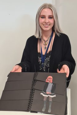 Maisie Bull holding her art piece